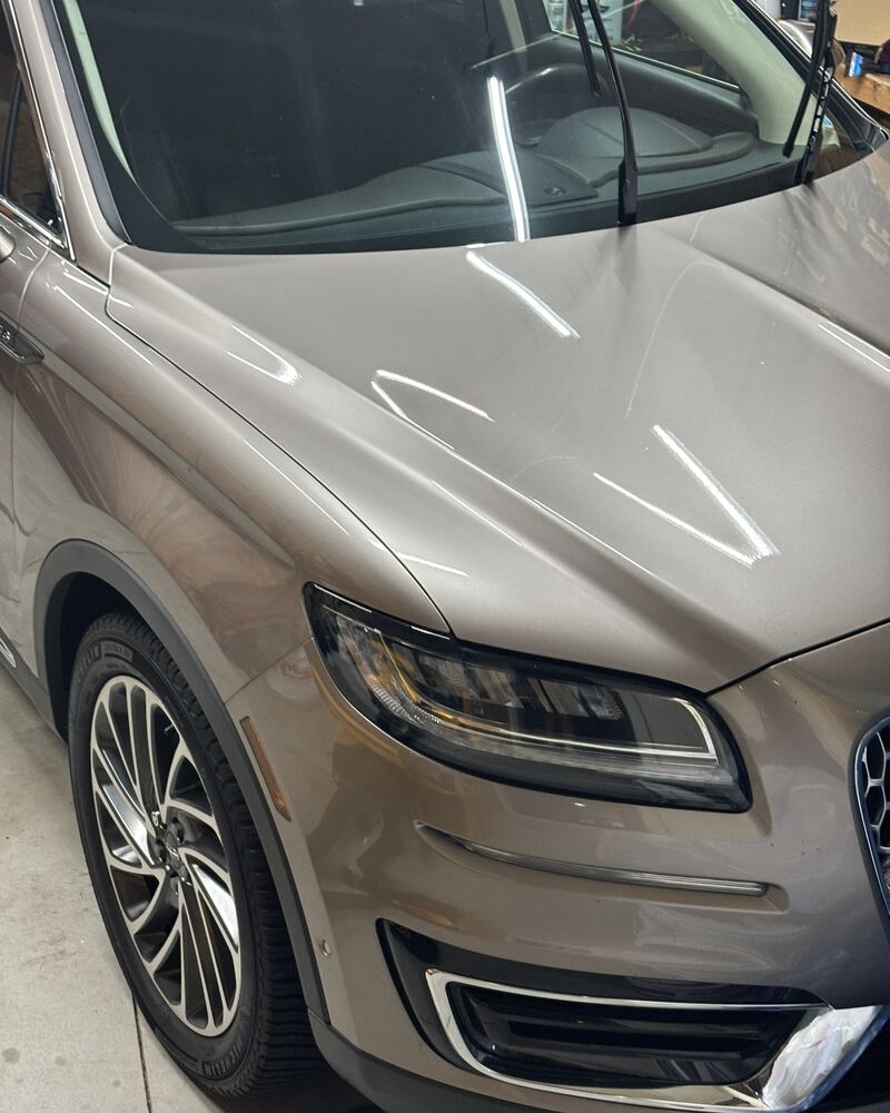 Bronze Lincoln SUV with a glossy, freshly coated hood and fender