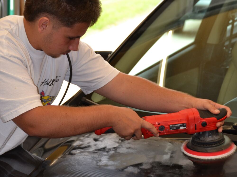 Isaac machine polishing the hood of a black car